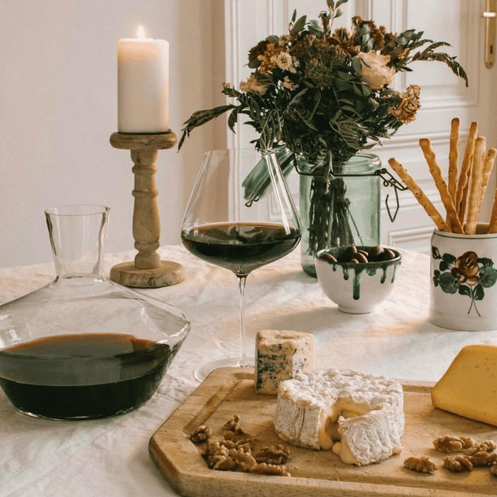 Grand verre à vin rouge avec plateau de fromages, ambiance cosy soirée détente