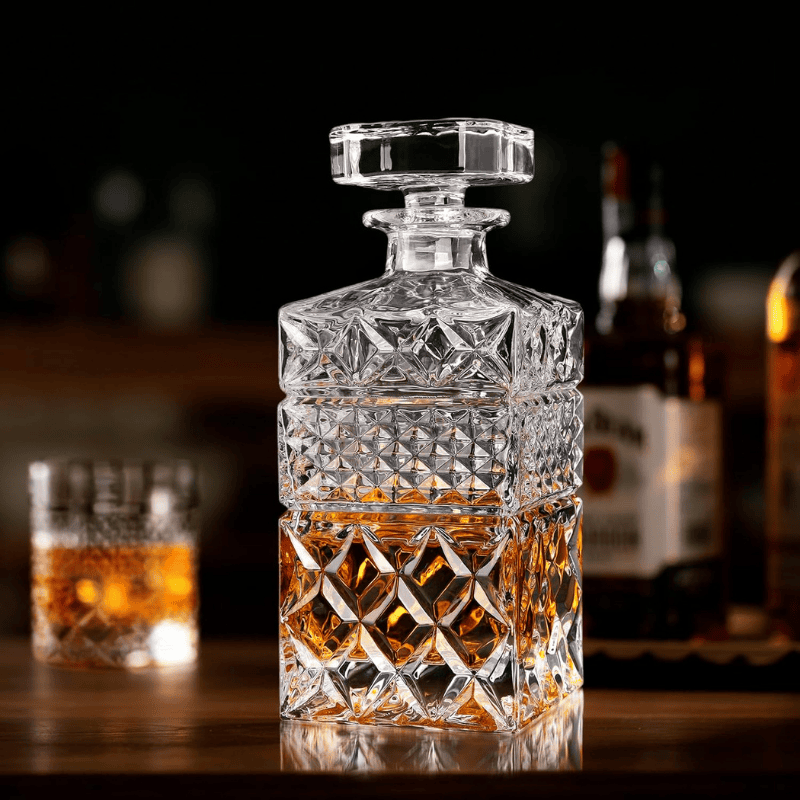 Carafe à whisky en cristal taillé motif écossais posée sur un buffet en bois sombre