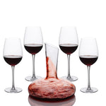 Carafe à décanter remplie de vin rouge entourée de quatre verres à pied