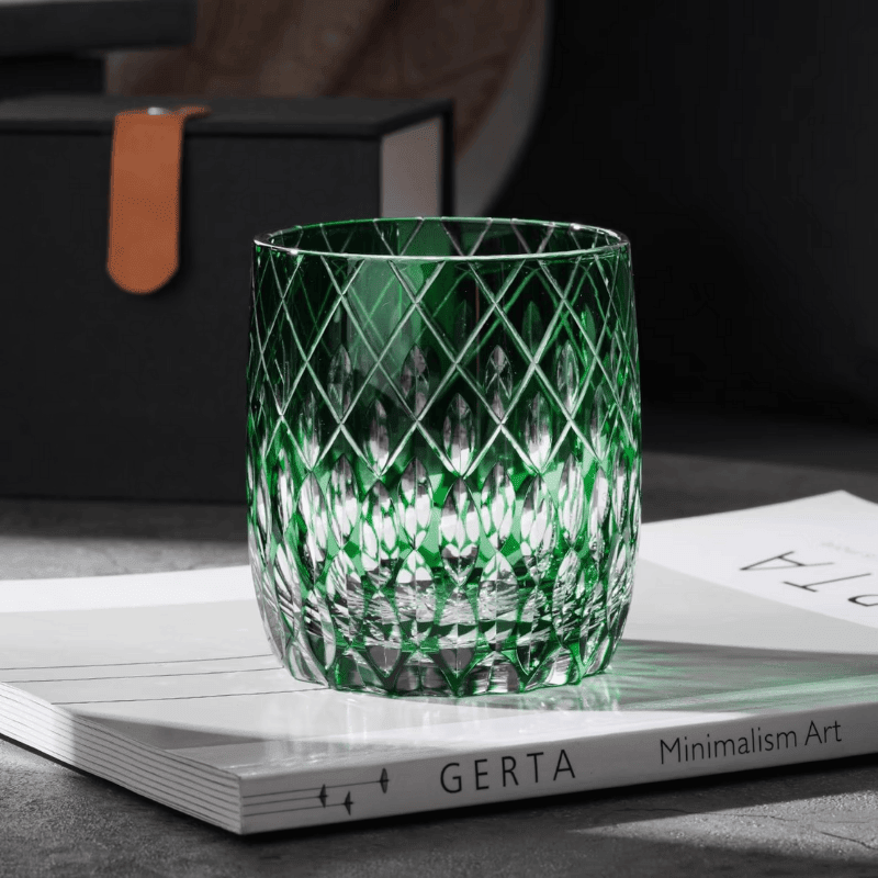 Verre à whisky en cristal avec glaçons, posé sur fond noir élégant